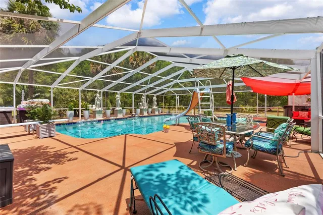 a view of a swimming pool with a patio and a garden