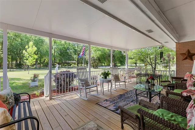 an aerial view of a residential houses with outdoor space and trees