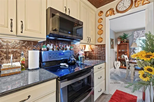 a kitchen with stainless steel appliances granite countertop a stove and cabinets