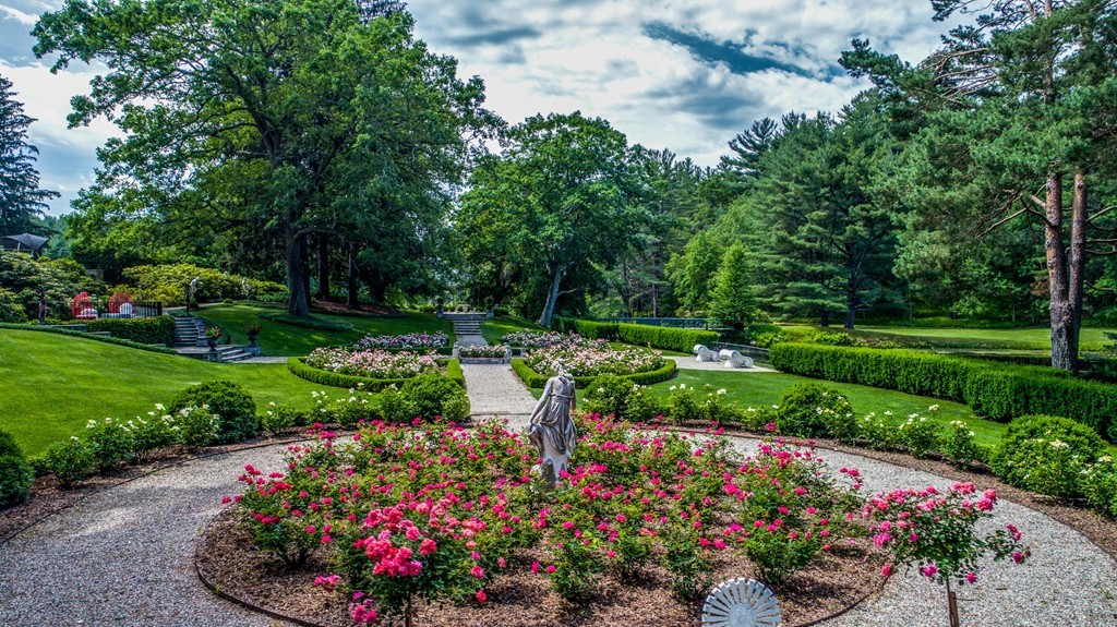 1075 Lowell Road Concord, MA 01742 - Photo 7 of 26 a view of a garden with a lot of flower plants and wooden fence