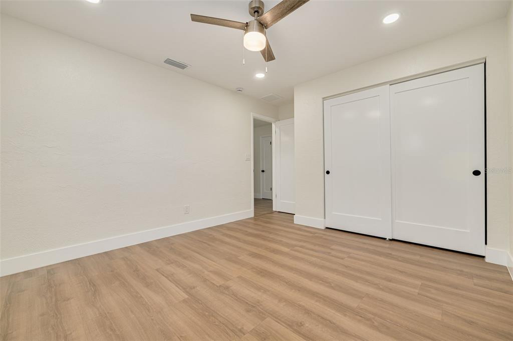 2034 58th Way North Clearwater, FL 33760 - Photo 25 of 35 an empty room with wooden floor and a ceiling fan
