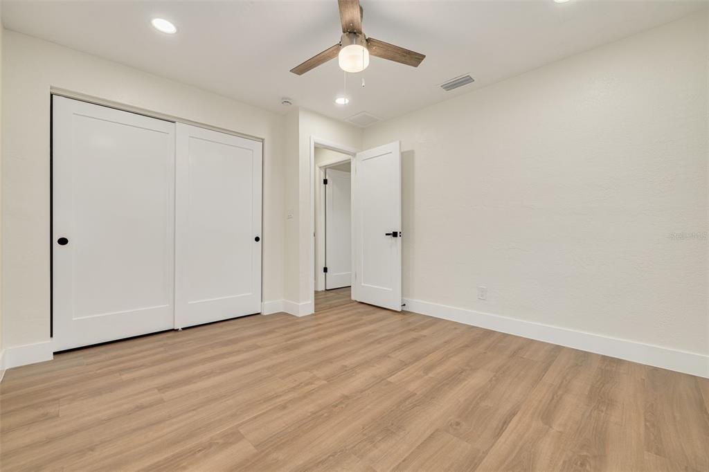 2034 58th Way North Clearwater, FL 33760 - Photo 29 of 35 wooden floor in an empty room with a ceiling fan