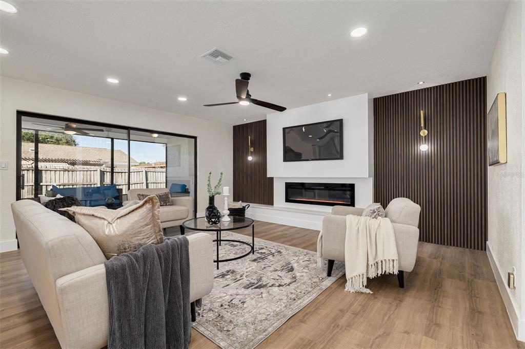 2034 58th Way North Clearwater, FL 33760 - Photo 7 of 35 a living room with furniture a fireplace and a flat screen tv