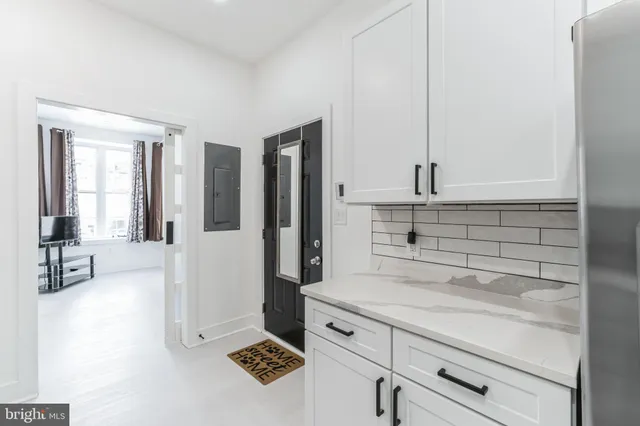 a kitchen with a refrigerator and white cabinets