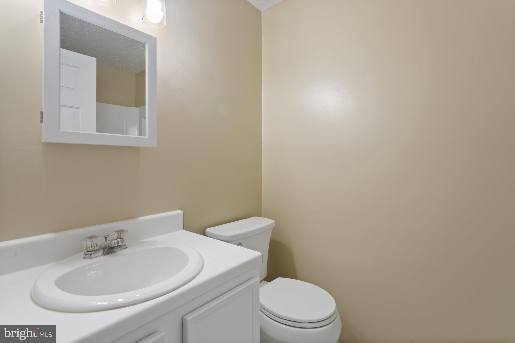731 Heather Ridge Drive Frederick, MD 21702 - Photo 25 of 26 a bathroom with a toilet a sink and mirror