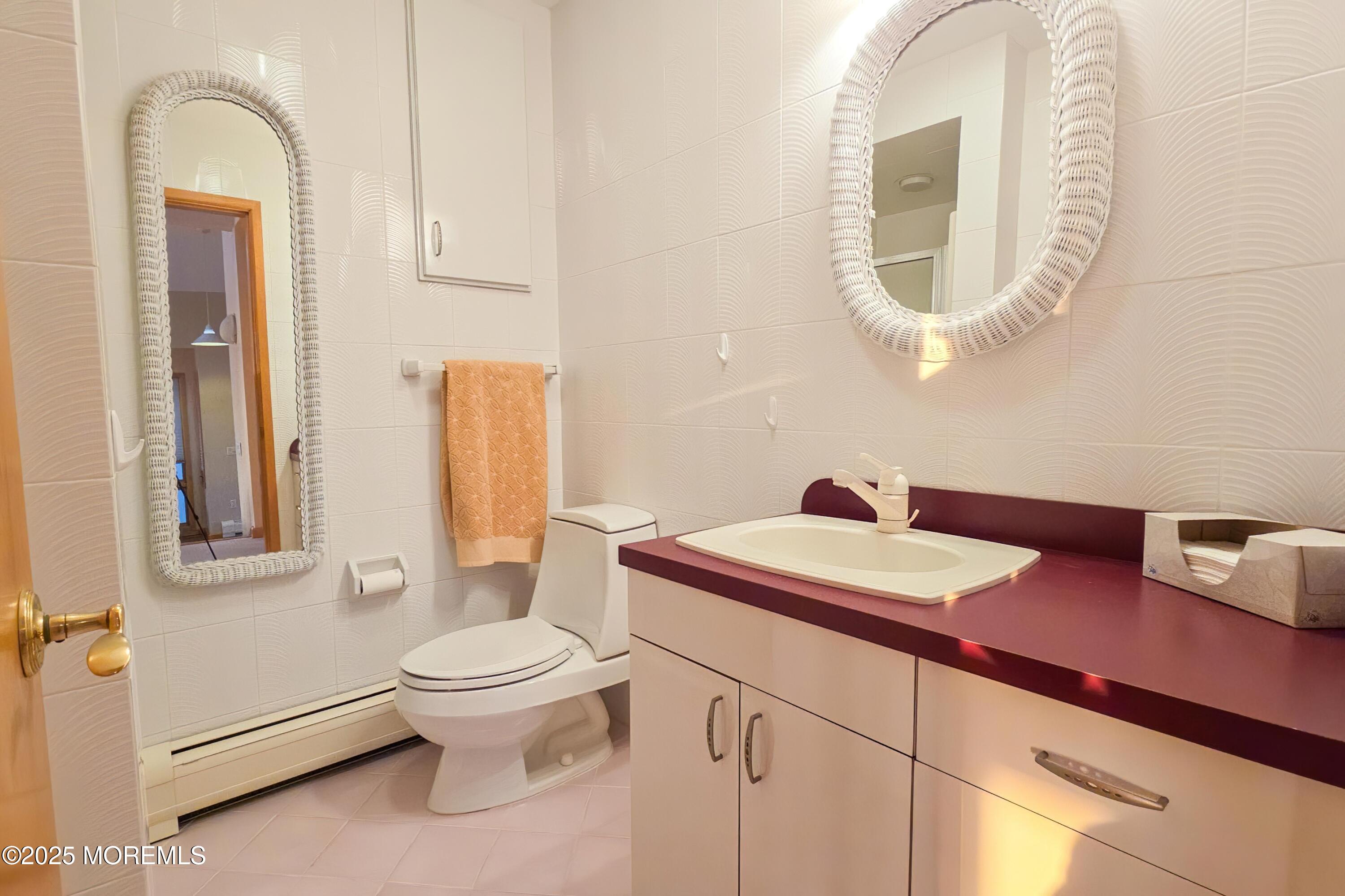 495 Boca Raton Drive Lavallette, NJ 08735 - Photo 36 of 48 a bathroom with a toilet a sink and a mirror