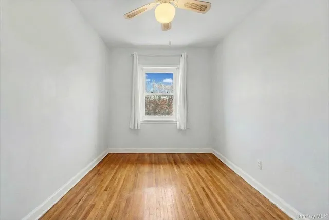 a view of a room with wooden floor and a window