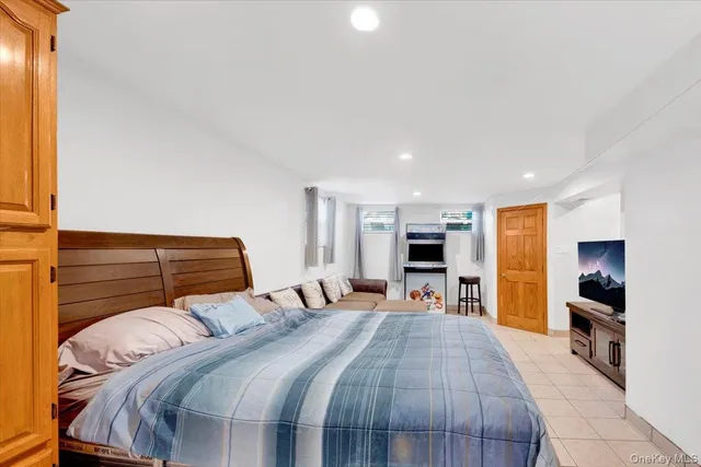 a bedroom with a large bed and a flat tv screen on a dresser