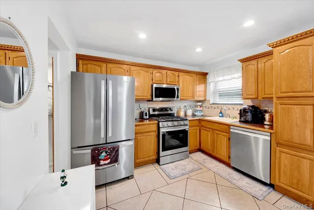 a kitchen with granite countertop a refrigerator a sink a stove top oven and kitchen island