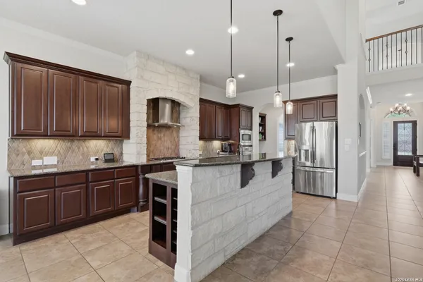 a kitchen with stainless steel appliances granite countertop a refrigerator and cabinets