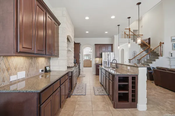 a kitchen with stainless steel appliances granite countertop a refrigerator and a stove