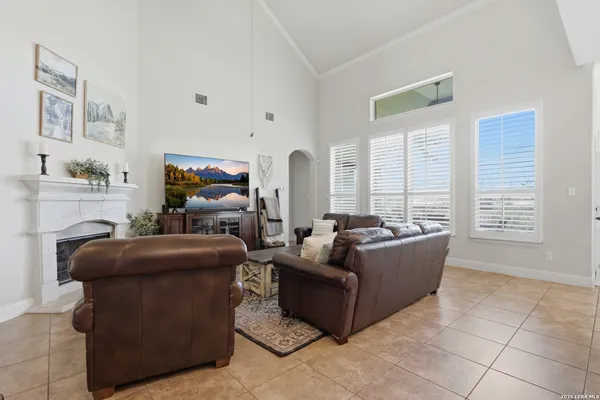 a living room with furniture kitchen view and a wooden floor