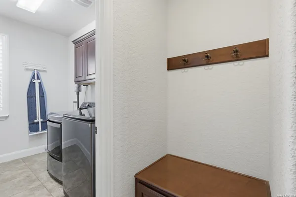 a utility room with stainless steel appliances granite countertop a sink and a washer dryer