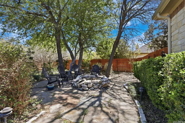 a view of a big house with a big yard and potted plants and large trees