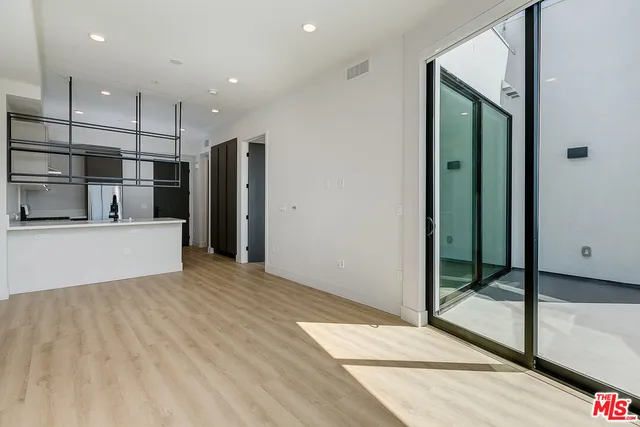 a view of a kitchen with kitchen island a refrigerator and a sink