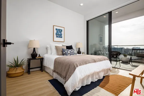 a bedroom with a bed a mirror and a window