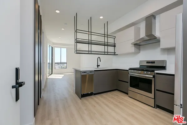 a kitchen with stainless steel appliances granite countertop a stove a sink and a refrigerator