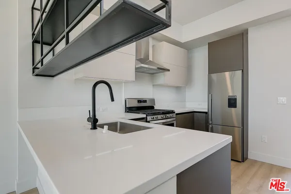 a kitchen with stainless steel appliances a sink a refrigerator and a stove