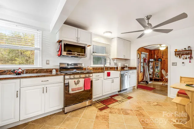 a kitchen with stainless steel appliances kitchen island granite countertop a refrigerator and a stove top oven