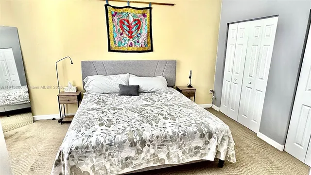 a bedroom with a bed and a large mirror on the dresser