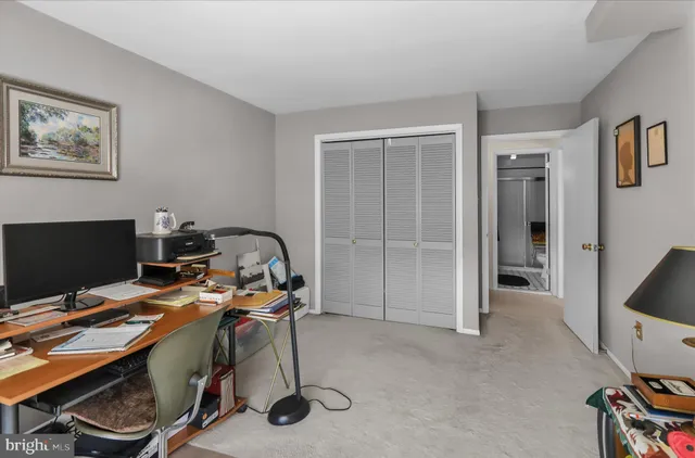 a view of a workspace with furniture and a window