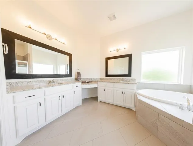 a bathroom with a granite countertop sink mirror and bathtub
