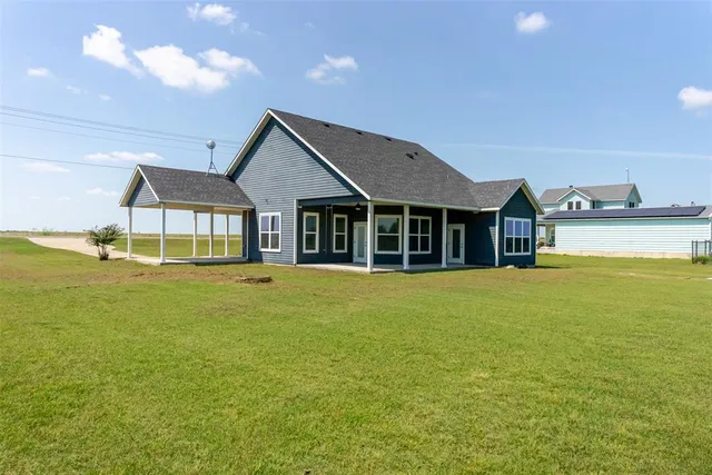 a front view of a house with a garden and lake view