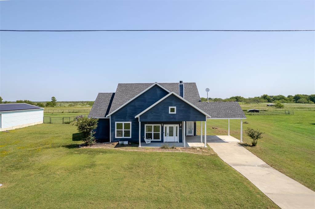 16806 Fm 3486 Terrell, TX 75160 - Photo 2 of 21 View of front of house featuring a rural view, an attached carport, covered porch, concrete driveway, and a chimney
