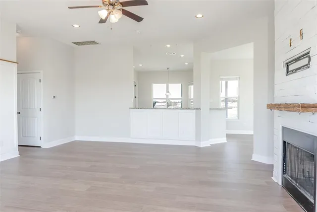 an empty room with wooden floor and fireplace