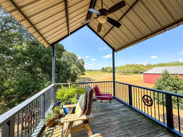 a view of a balcony with wooden floor and outdoor seating