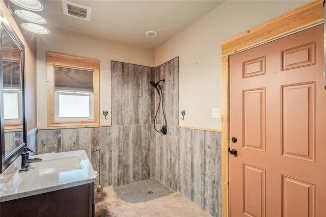 a bathroom with a shower sink and mirror