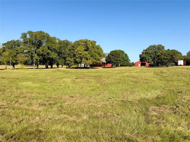 a view of a field with some trees in the background