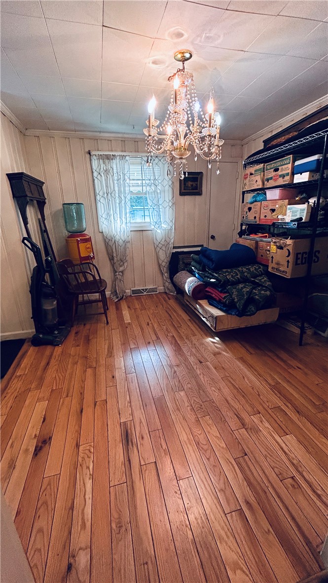 608 29 N Bypass Anderson, SC 29621 - Photo 2 of 20 Hardwood flooring extends throughout this versatile room, illuminated by a classic chandelier.