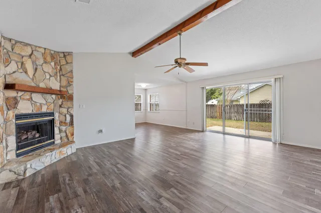 a view of an empty room with a fireplace and a window