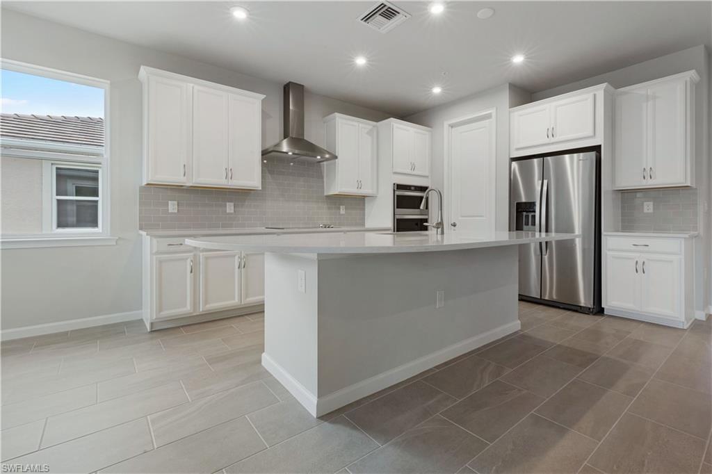 4670 Arboretum Circle, Unit 203 Naples, FL 34112 - Photo 10 of 33 a large kitchen with stainless steel appliances granite countertop a refrigerator and a stove top oven