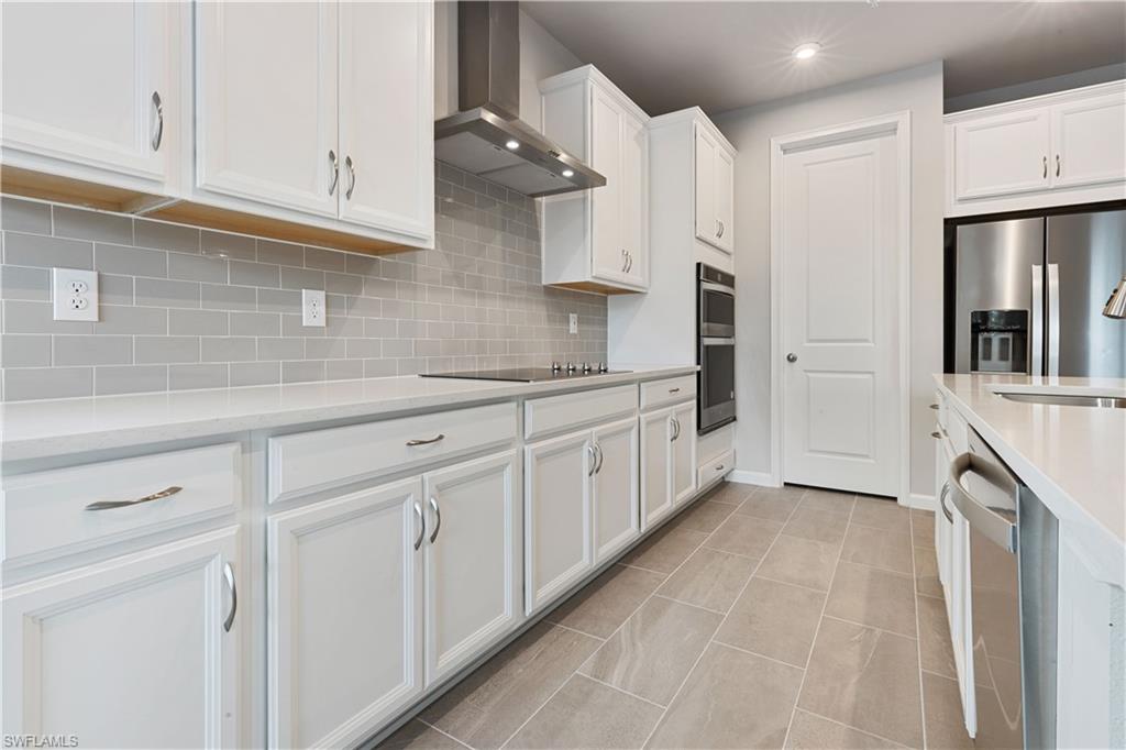 4670 Arboretum Circle, Unit 203 Naples, FL 34112 - Photo 13 of 33 a kitchen with stainless steel appliances granite countertop white cabinets and a refrigerator