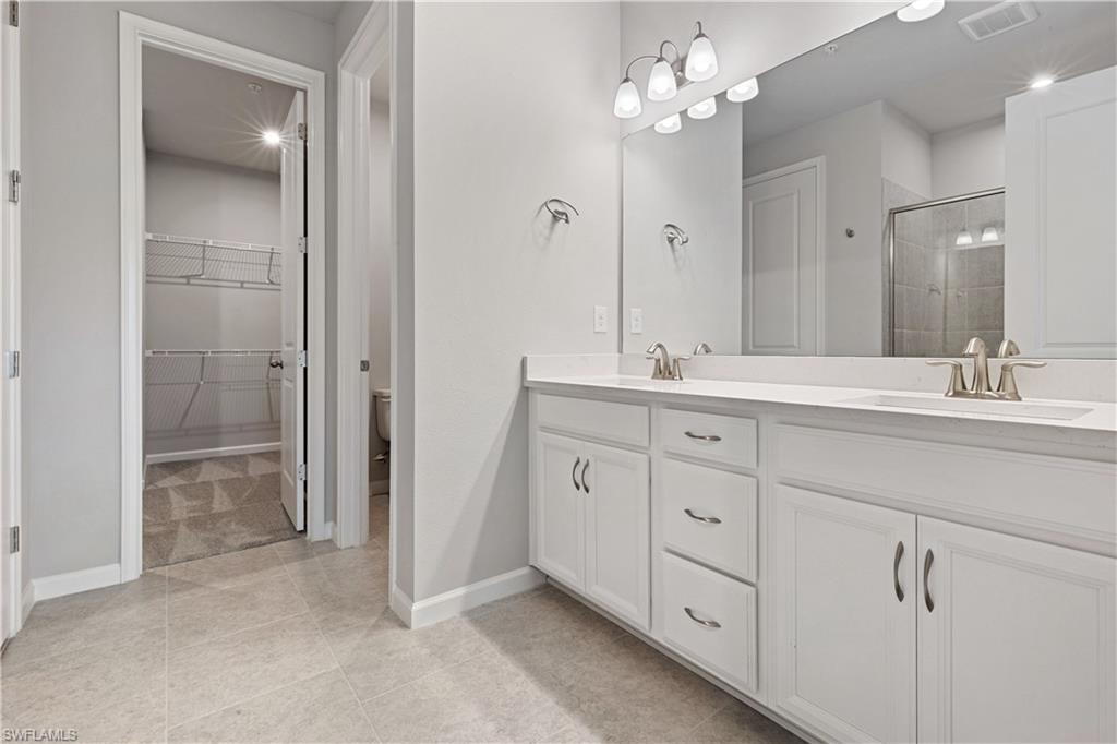 4670 Arboretum Circle, Unit 203 Naples, FL 34112 - Photo 26 of 33 a spacious bathroom with a double vanity sink a shower and a mirror