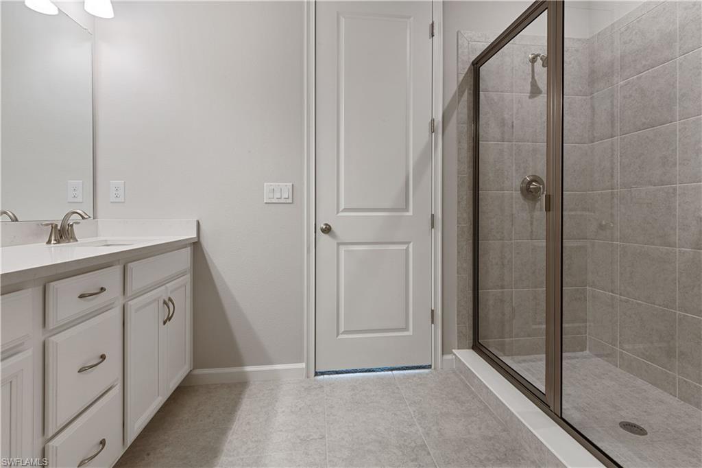 4670 Arboretum Circle, Unit 203 Naples, FL 34112 - Photo 28 of 33 a spacious bathroom with a double vanity sink a mirror and shower
