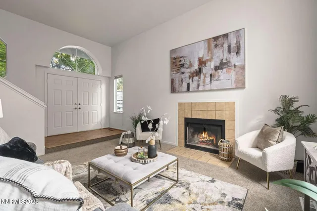 a living room with furniture a fireplace and a large mirror with wooden floor