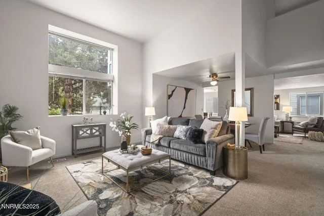 a living room with furniture a large window and a table