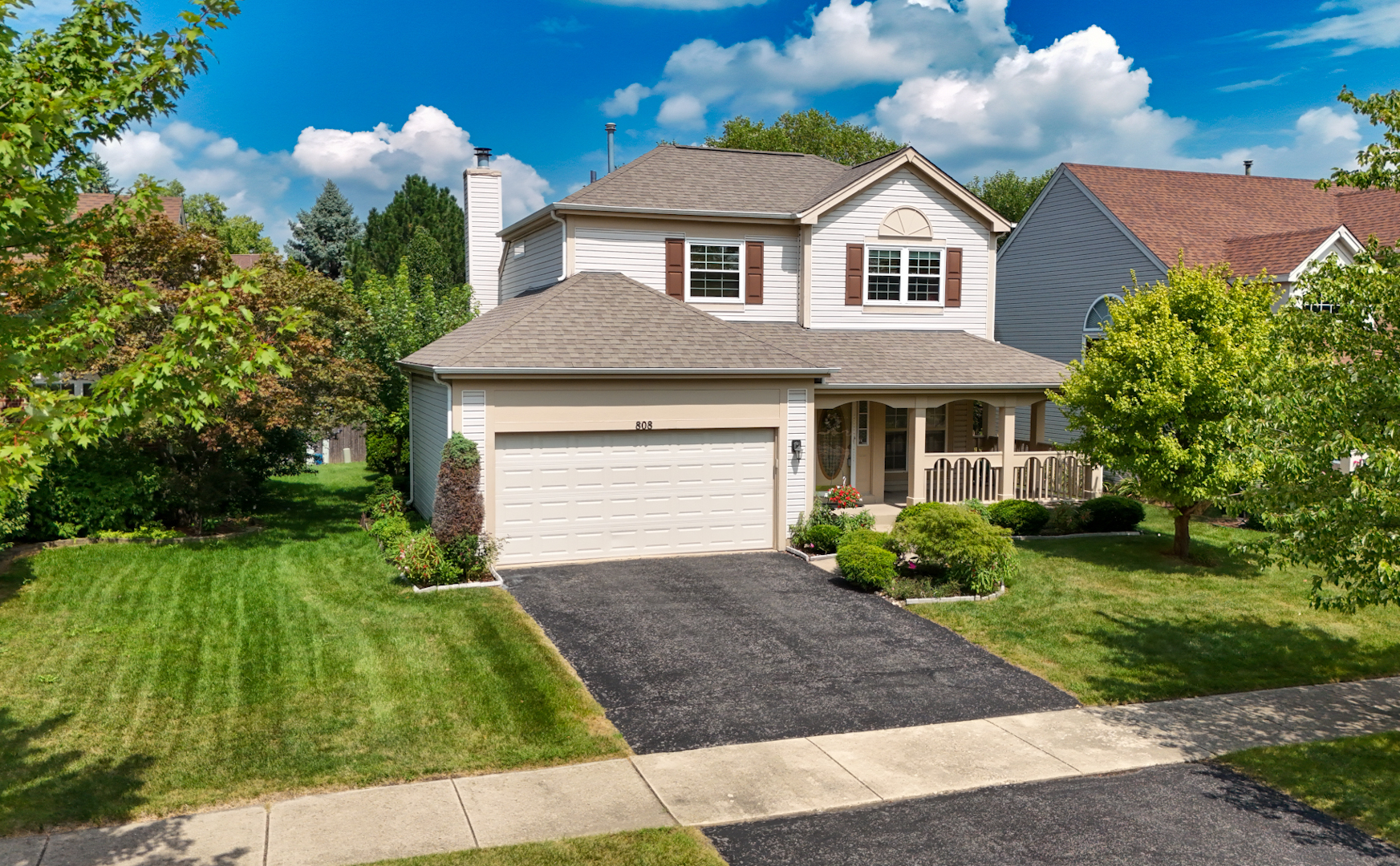 a front view of a house with a garden and yard