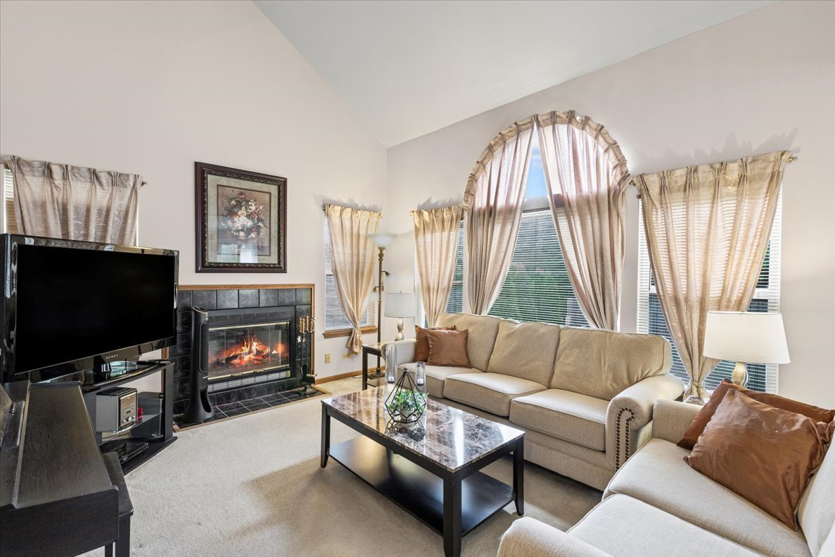 808 Violet Circle Naperville, IL 60540 - Photo 4 of 31 a living room with furniture a flat screen tv and a fireplace