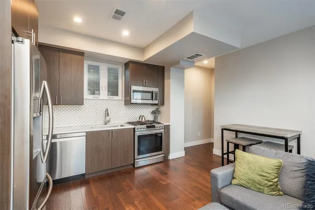 a kitchen with stainless steel appliances granite countertop a refrigerator and a stove top oven