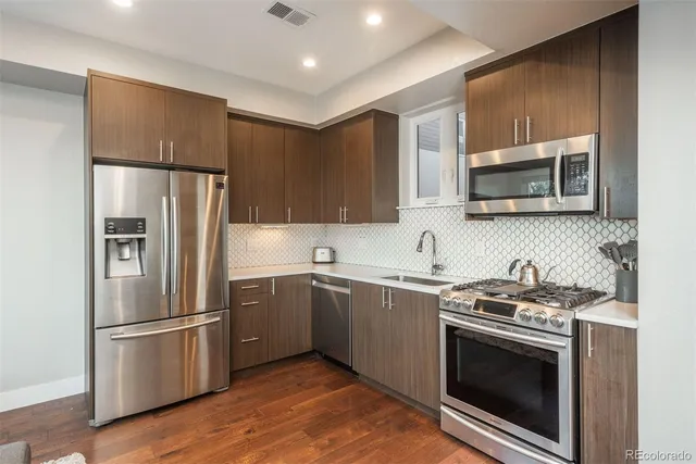 a kitchen with stainless steel appliances granite countertop a stove a refrigerator and a microwave