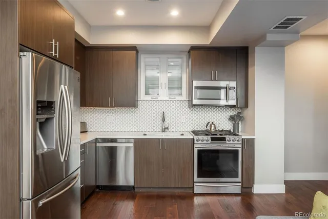 a kitchen with stainless steel appliances and wooden cabinets