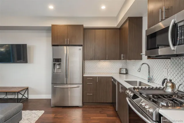 a kitchen with stainless steel appliances a refrigerator a stove a sink and a microwave