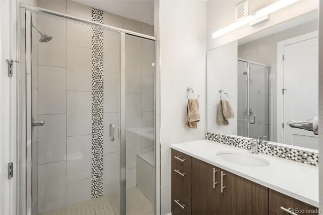 a bathroom with a shower sink and mirror
