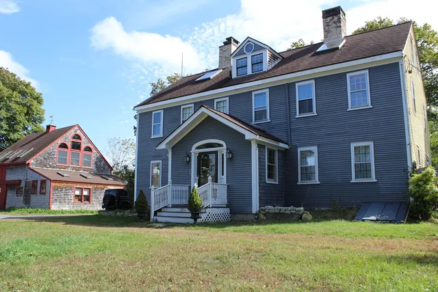 a front view of a house with a garden and yard