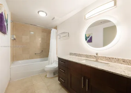 a bathroom with a granite countertop sink a toilet and a mirror