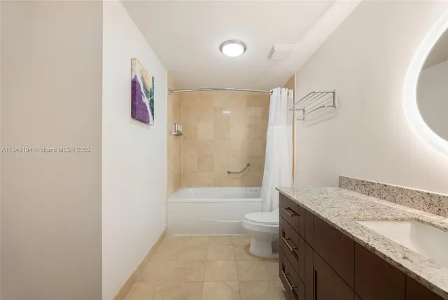 a bathroom with a granite countertop sink a toilet and shower